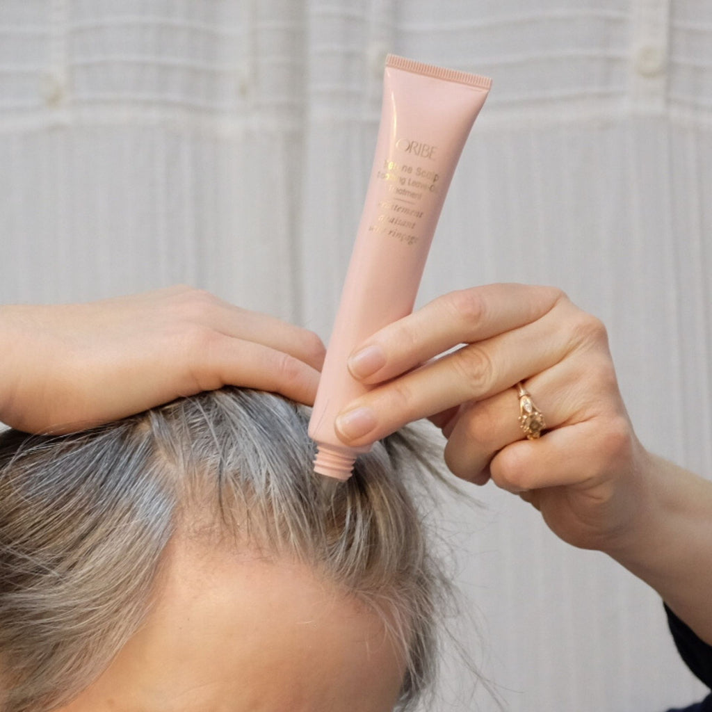 Person applying Oribe Serene Scalp Leave-On-Treatment for dry scalp.